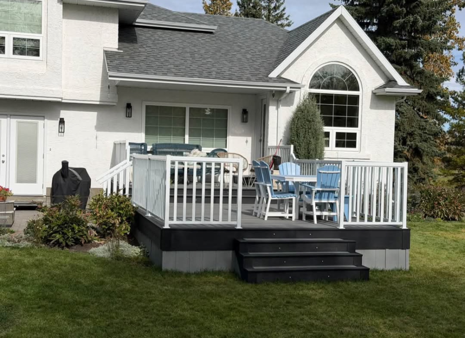 Two-tier grey composite deck with white aluminum railing and black stairs in Parkland Beach, AB, resurfaced by Green Ladder Contractors